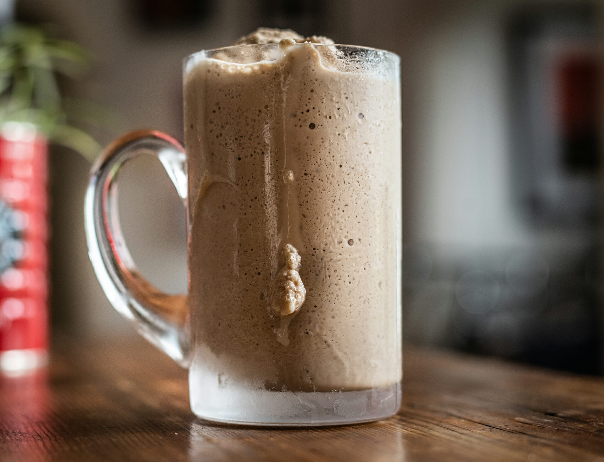 Frosty glass mug filled with a French Market Mocha Milkshake on a wooden counter